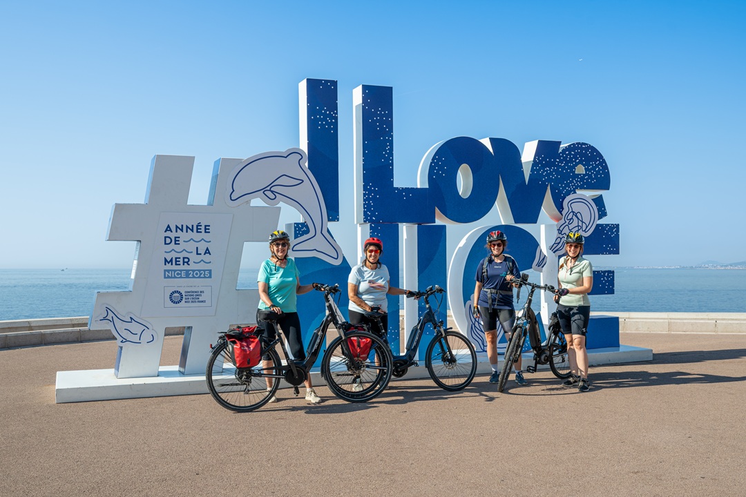 Bike group in front of Nice-Sign